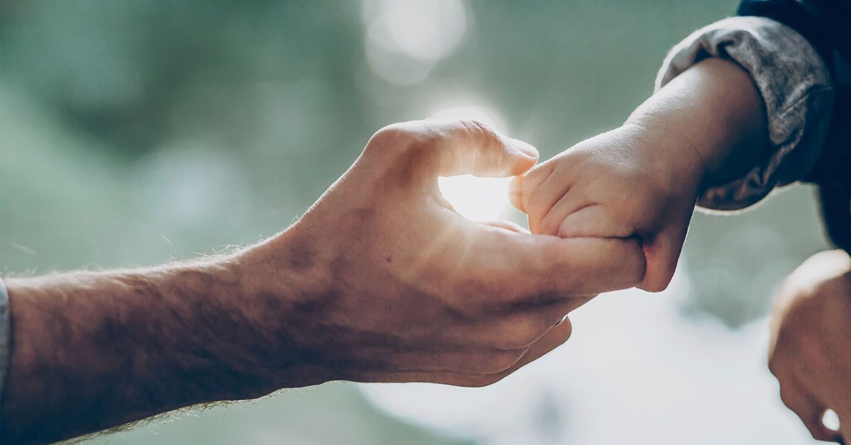 father holding his son's hand